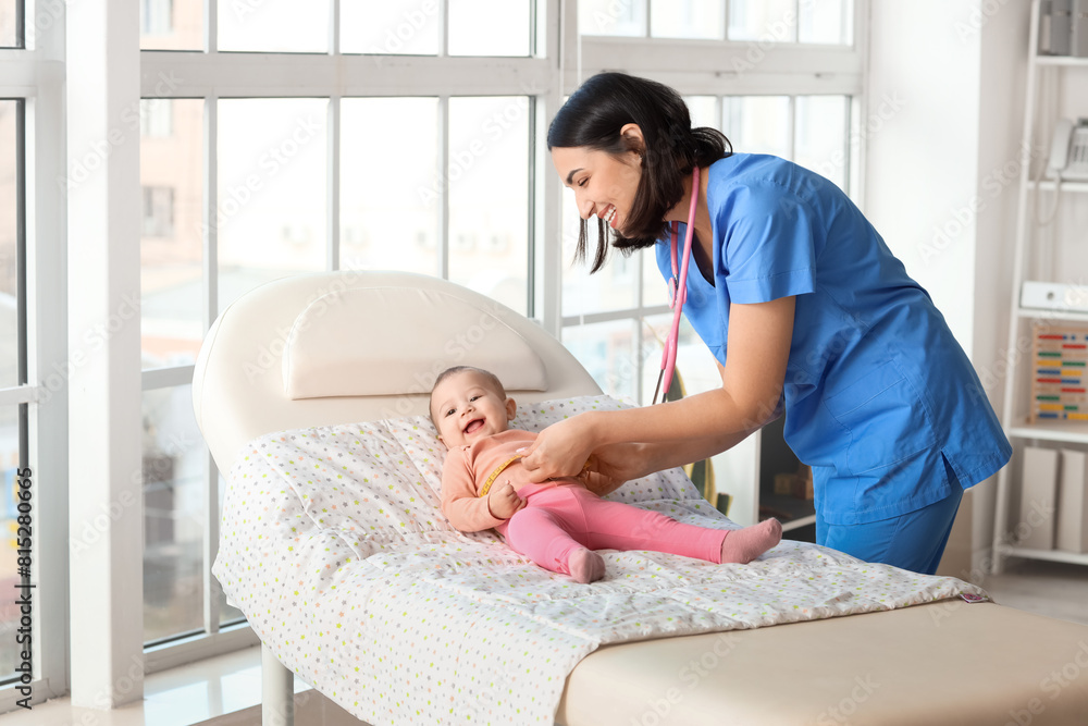 Female pediatrician measuring little baby's chest on couch in clinic Female pediatrician measuring little baby's chest on couch in clinic
