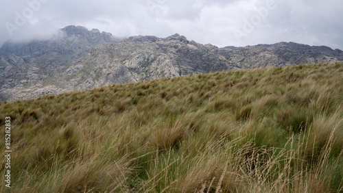 Panorama view fo the yellow grassland in the hills under a cloudy sky