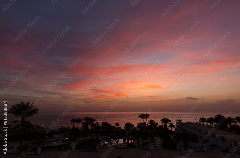 Sunrise on the sea coast. The movement of the sun and clouds across the sky. Park recreation areas of Egypt. Garden and landscape design.