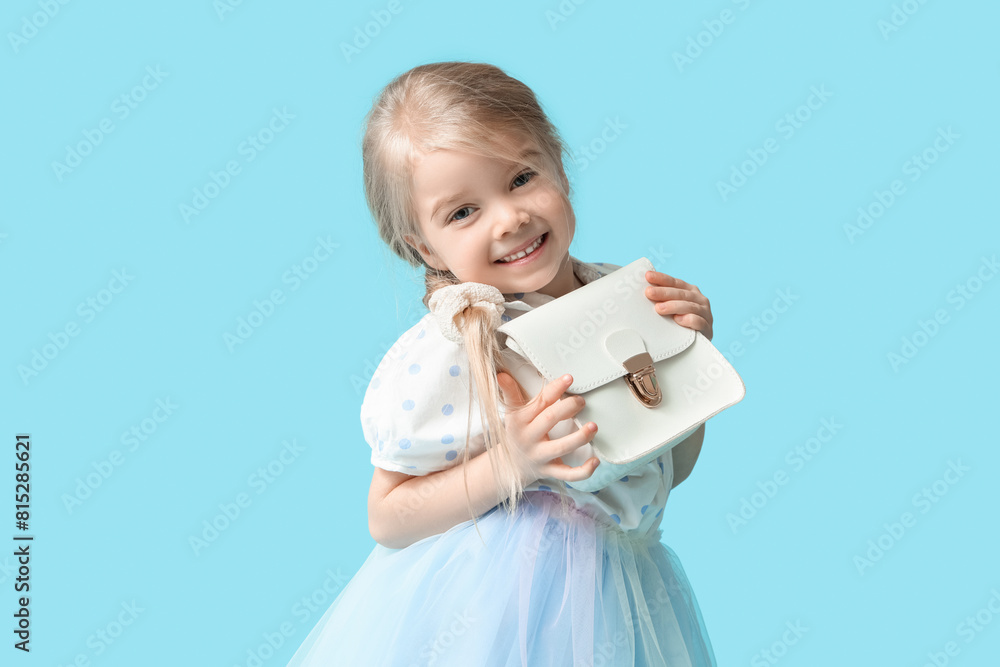 Cute little girl with stylish white bag on blue background Cute little girl with stylish white bag on blue background