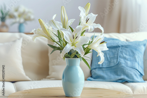 A serene bouquet of white lilies in a pale blue vase on a light oak table, with a sky blue linen pillow on a soft white sofa in the background.