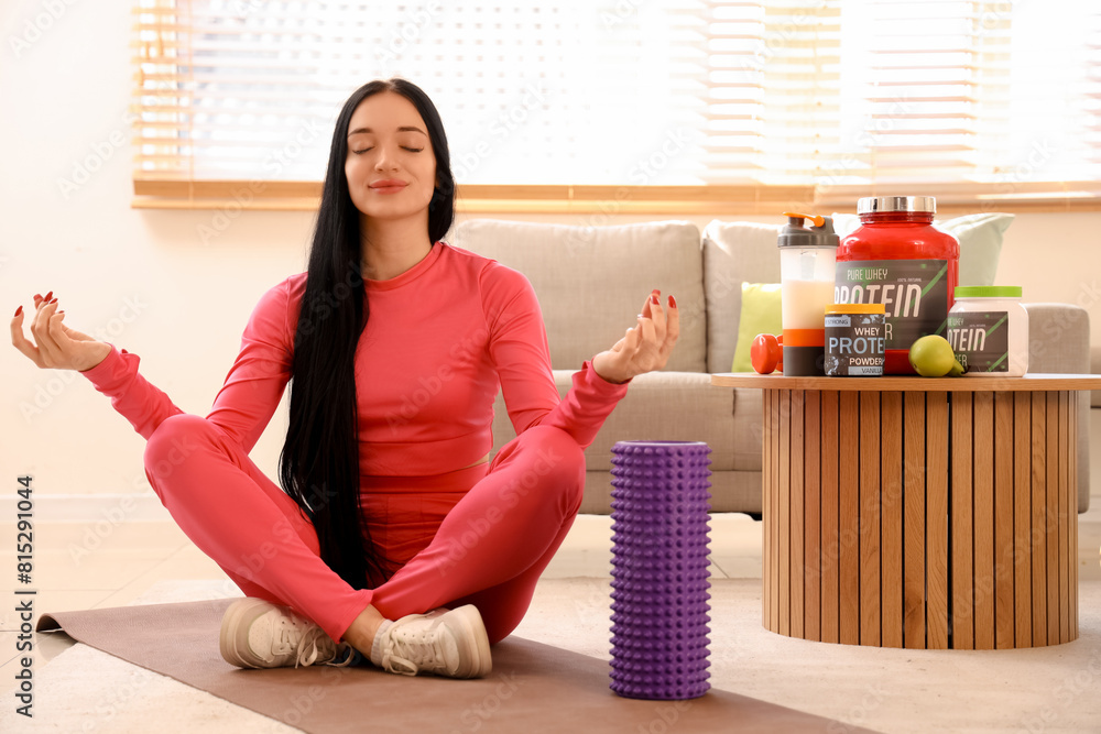 Sporty young woman with protein meditating at home Sporty young woman with protein meditating at home