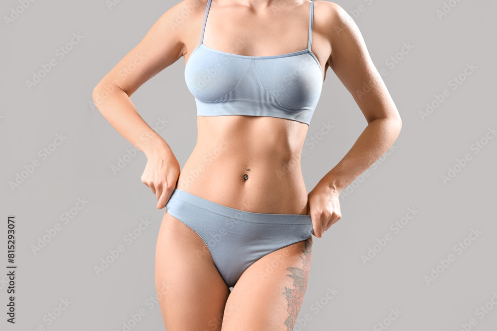 Beautiful young woman in light blue underwear on grey background Beautiful young woman in light blue underwear on grey background