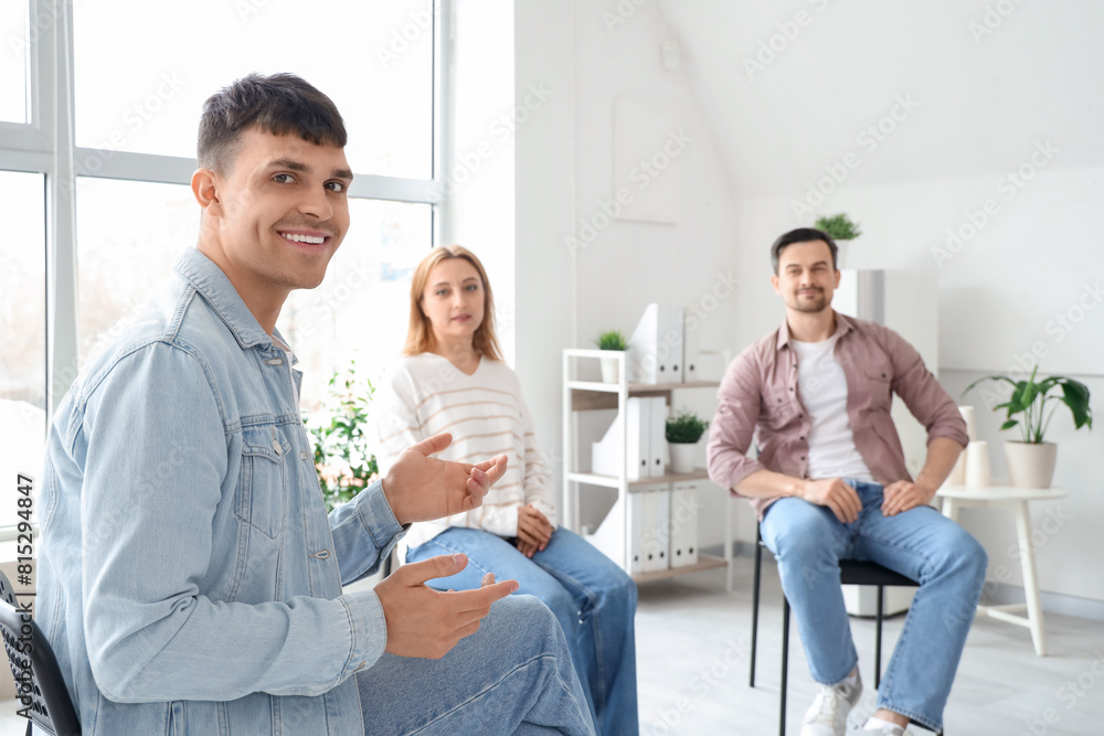 Obraz premium Young man sitting at group therapy session