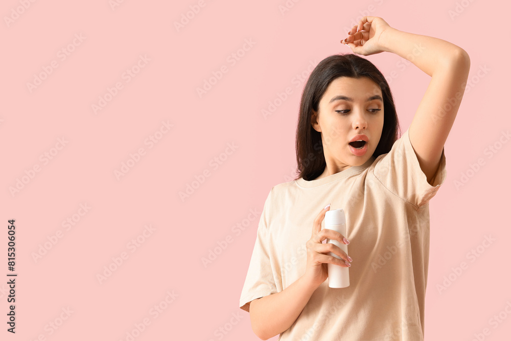Shocked young woman with deodorant on pink background Shocked young woman with deodorant on pink background