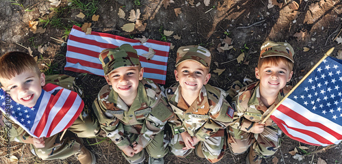 Memorial Day cheer: Four children dressed in soldier uniforms holding flags, viewed from above. photo