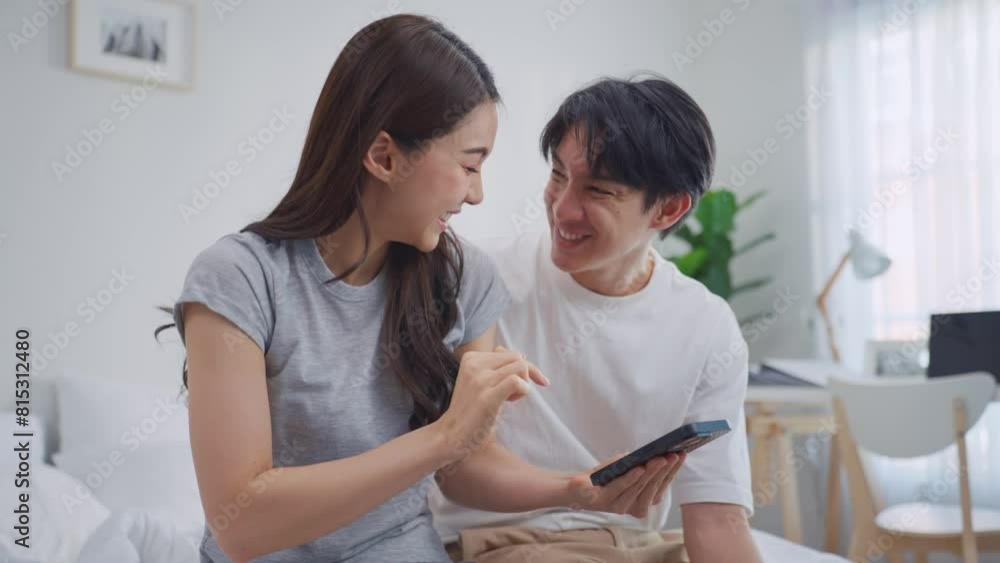 Asian young couple using smartphone shopping online in bedroom at home. Asian young couple using smartphone shopping online in bedroom at home.