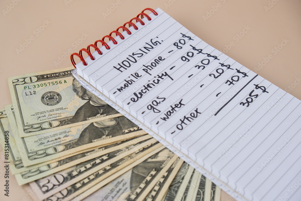 Naklejka premium Counting expenses bills on housing electricity, gas, water. Banknotes of dollar cash around. High prices for energy inflation crisis. Cut back on spending. Savings rate