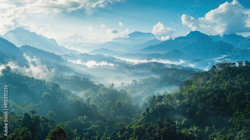 A panoramic vista of a tropical mountain range  with mist-shrouded peaks rising majestically against a backdrop of clear blue skies  offering a glimpse into the awe-inspiring grandeur of untouched.