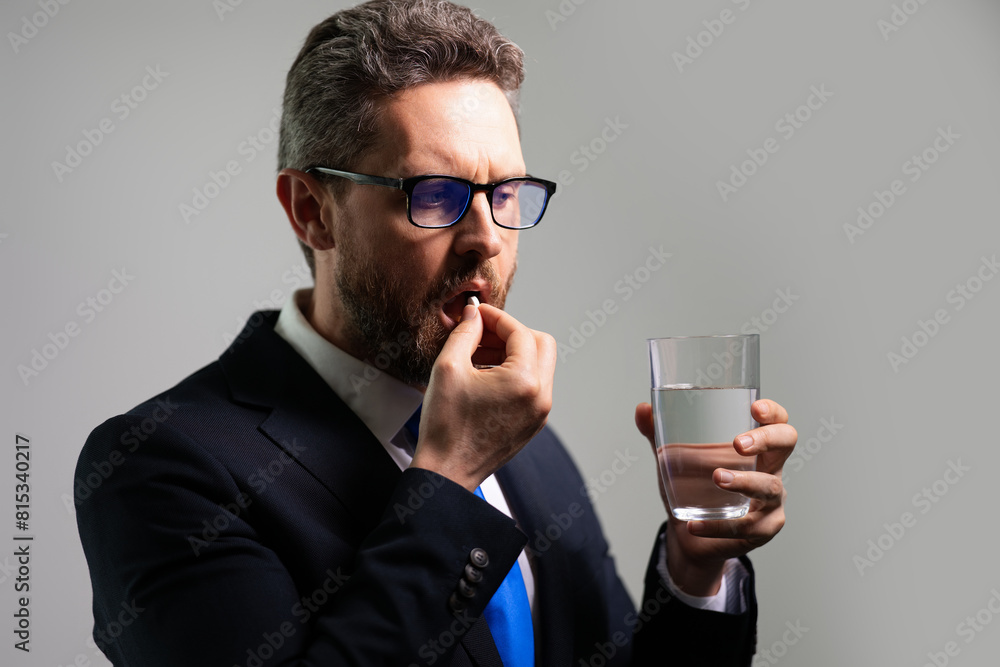Medicine pill from headache migraine. Man with headache on isolated gray studio background. Man feel pain rubbing dry eyes fatigued from work. Medicine pill from headache migraine. Man with headache on isolated gray studio background. Man feel pain rubbing dry eyes fatigued from work.