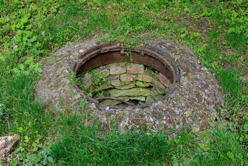 A hole in the ground with grass growing around it © Iurii Gagarin