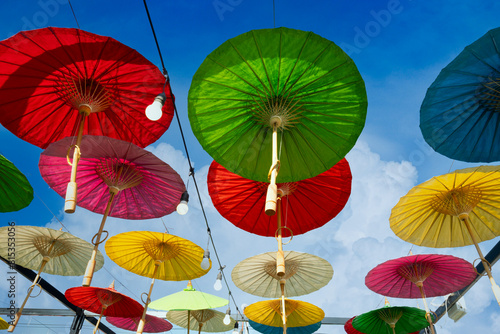 Mulberry paper umbrella that are hung over the road to decorate on the background of the bright sky in the Bo Sang umbrella festival that is the source of producing and selling mulberry paper umbrella