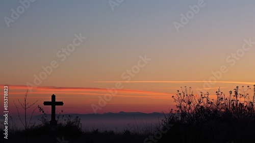 Silhouette of a cross against the soft hues of a dawn sky, creating a peaceful and reverent atmosphere with copy space