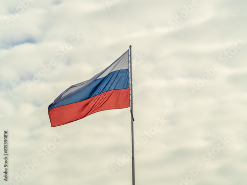 Free Download Russian tricolor flag waving in the wind against a blue sky. - GFXLoad