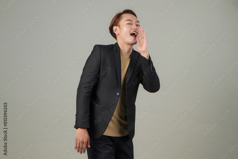 portrait of happy asian businessman wearing suit shouting with cupping hand on isolated background portrait of happy asian businessman wearing suit shouting with cupping hand on isolated background