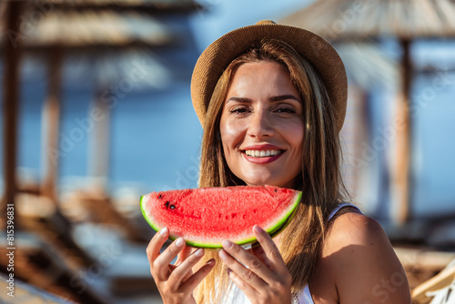 Young beautiful woman eating juicy watermelon on the beach.