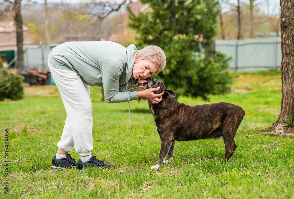Mature woman playing with her dog outdoors Mature woman playing with her dog outdoors