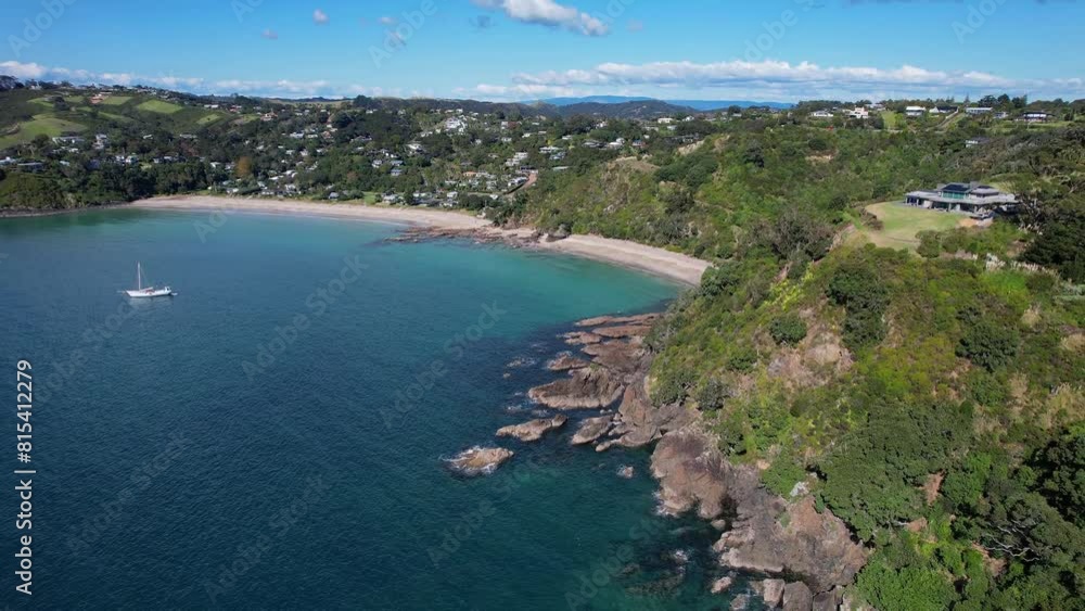 Palm Beach With Rocks And Green Foliage In Mawhitipana Bay, Auckland, New Zealand. aerial pullback shot Palm Beach With Rocks And Green Foliage In Mawhitipana Bay, Auckland, New Zealand. aerial pullback shot