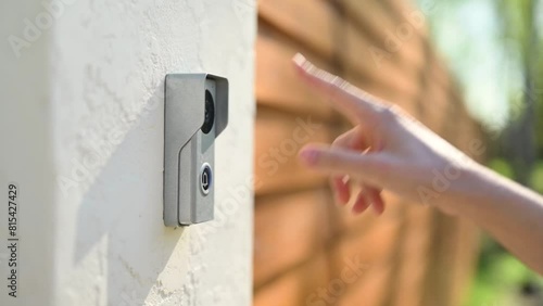 A woman's finger presses the bell of a private property. Close up, slow motion
