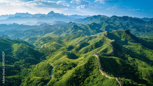 Aerial view of the Great Wall of China stretching across rugged mountains and valleys, with sections winding over steep ridges and through lush forests. 