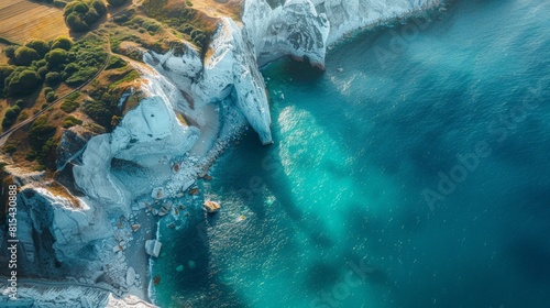 Aerial view of the White Cliffs of Dover in England, with their striking white chalk faces rising from the blue waters of the English Channel. 