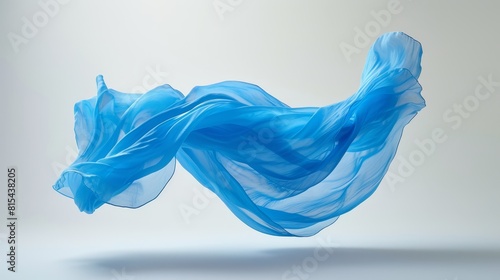  Blue fabric flutters against gray backdrop  wind s touch creates light reflection beneath