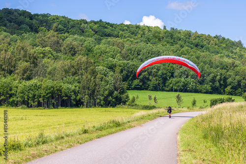 Paraglider on a country road in a rural landscape photo