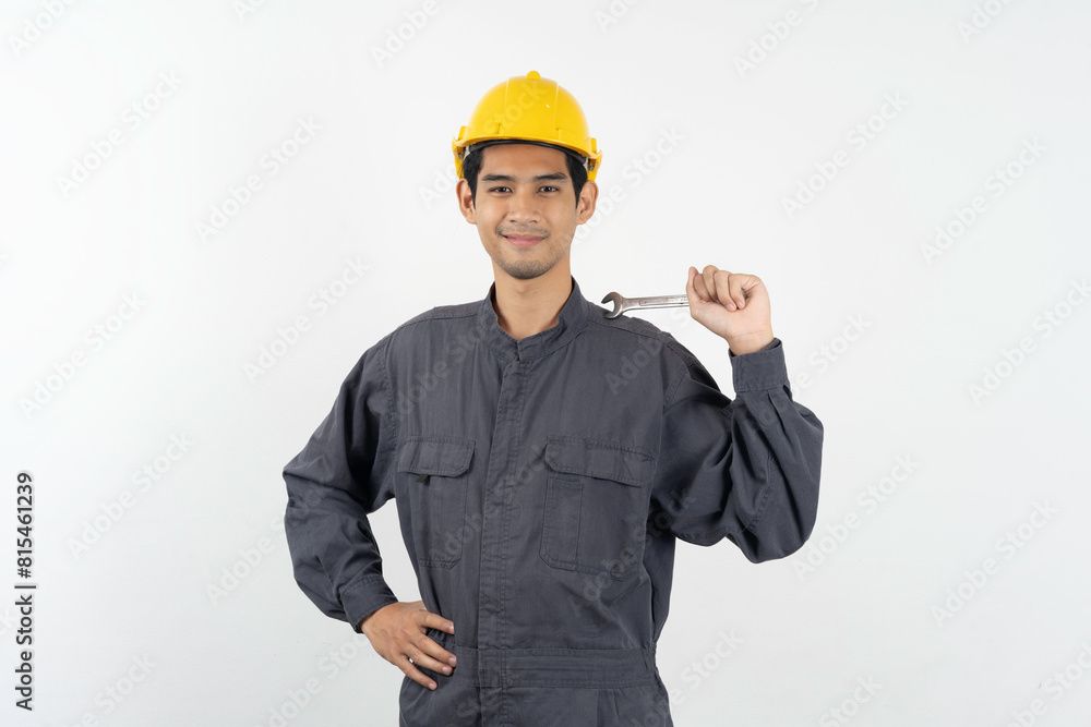 Repairman mechanic, Asian young handyman holding tools and wearing yellow safety helmet isolated on background. Repairman mechanic, Asian young handyman holding tools and wearing yellow safety helmet isolated on background.