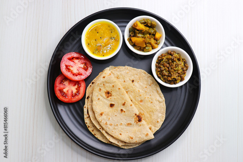 Roti and bhaji. Indian vegetarian Thali or platter includes akhha Masoor sabzi, dal, fansi or beans ki sabji, and chapati. Indian food is served in a plate or thali. Copy Space. healthy Veg Thali.