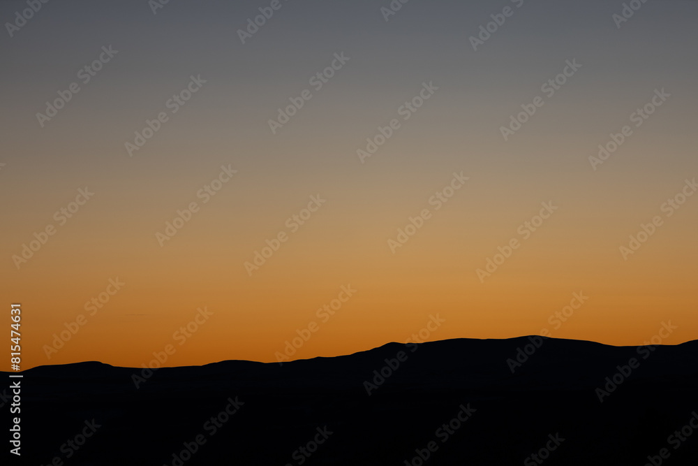 A silhouette of Norwegian mountains during sunset with gradient sky A silhouette of Norwegian mountains during sunset with gradient sky