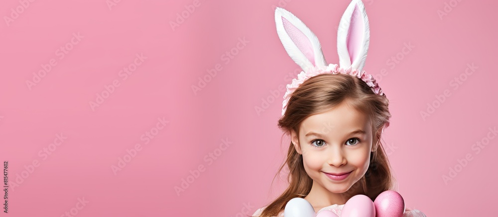 A charming young girl wearing bunny ears happily poses with Easter gift eggs in hand against a vibrant pink background creating a visually appealing copy space image A charming young girl wearing bunny ears happily poses with Easter gift eggs in hand against a vibrant pink background creating a visually appealing copy space image