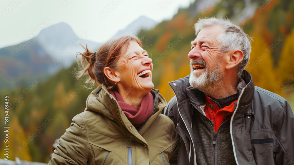 Elderly man and woman laugh joyfully against a mountain backdrop Elderly man and woman laugh joyfully against a mountain backdrop