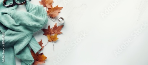 Top view of a cozy autumn flat lay on a white concrete background featuring warm women s clothing in the color of Tiffany including a jacket shoes and scarf with ample copy space for customization photo