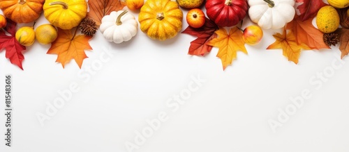 A vibrant fall themed flat lay with pumpkin golden leaves and a white background perfect for a copy space image during apple season