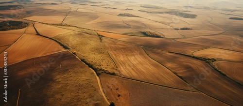 A scenic aerial perspective captures a picturesque countryside scene showcasing a road meandering through vast brown agricultural fields with fertile soil Deliberate use of composition allows for a c