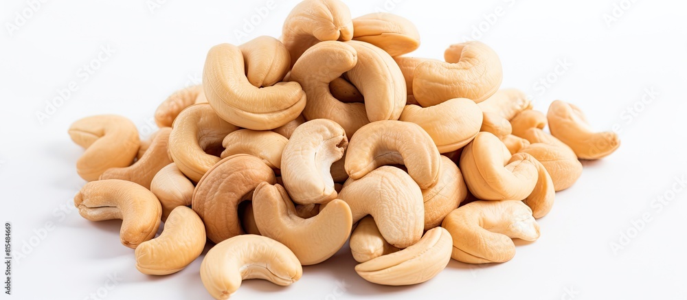 A pile of cashew nuts on a white background seen from above with empty space for additional elements A pile of cashew nuts on a white background seen from above with empty space for additional elements