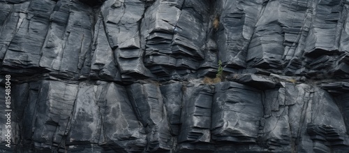A close up of a rough and dilapidated stone wall resembling a dark cliff The gray texture of the stone or rock mountains creates a background with plenty of copy space for geology and mountaineering