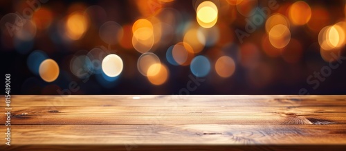 A brown wooden table with an empty surface is placed against a colorful blurred background suitable for showcasing products and creating website banners with copy space image
