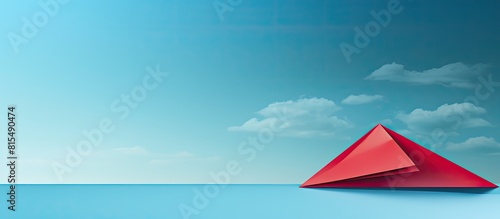 A panoramic shot captures a leadership concept with a top view of a red paper plane on a blue background offering ample copy space