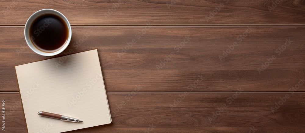 Top view of a wooden office desk table with a blank notebook page a pen and a cup of coffee The image has copy space and is captured in a flat lay style Top view of a wooden office desk table with a blank notebook page a pen and a cup of coffee The image has copy space and is captured in a flat lay style