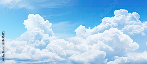 A wide background with a blue sky and fluffy clouds perfect for a summer template or backdrop image with copy space