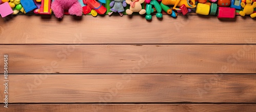 A vibrant frame made of colorful kids toys is displayed on a wooden background as seen from a top view perspective The image is laid flat and provides ample space for text