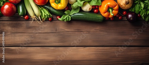 A copy space image featuring organic summer vegetables displayed on a rustic brown wooden background providing a perfect backdrop for your text