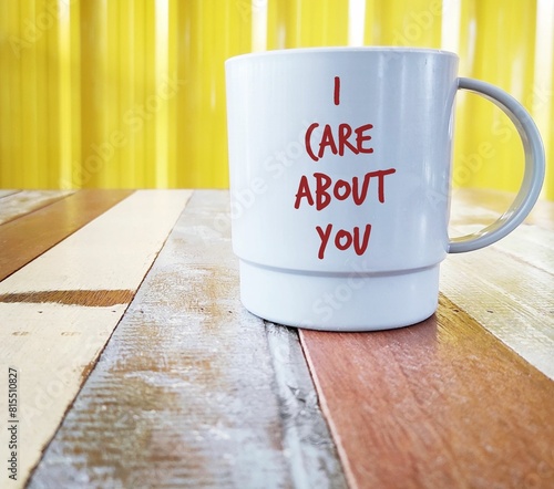 White plastic cup with text written I CARE ABOUT YOU, to show support to depressed or stressful friends by expressing to let someone know you concern and they are important.