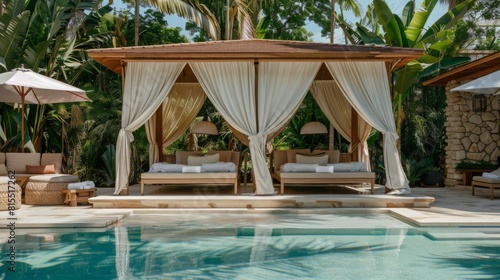 A serene cabana with flowing curtains by a tranquil resort swimming pool, surrounded by lush greenery. photo