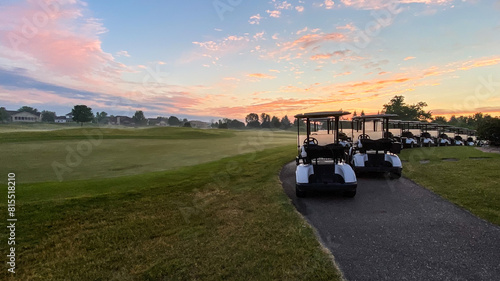 Fotografie Golf Carts Lined Up Ready for the Day at Sunrise with Pink Skies
