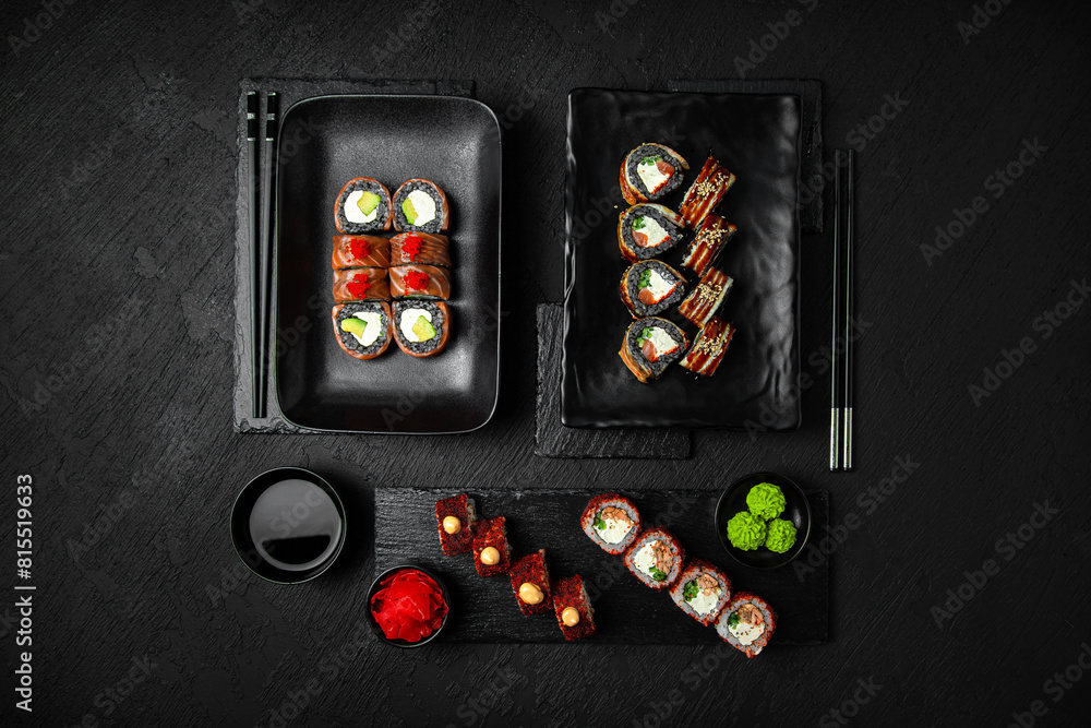 Sushi set composition on black background. The Art of Japanese Cuisine. Food photography for menu and sushi bar decoration Sushi set composition on black background. The Art of Japanese Cuisine. Food photography for menu and sushi bar decoration