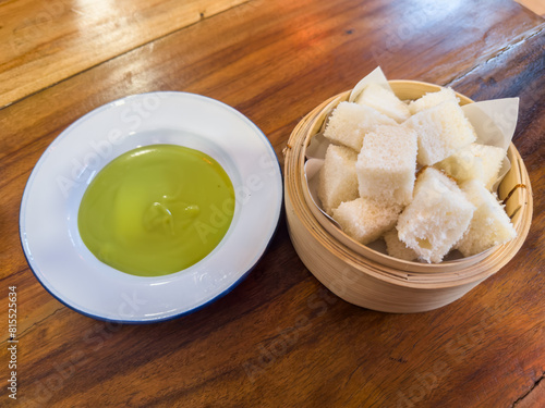 Pandan Kaya with Steamed Bread in bammboo basket. Steamed bun served with sweet green custard dip. photo