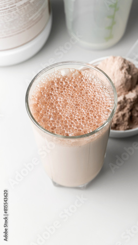 Protein drink cocktail in a glass and whey protein powder in a measuring scoop