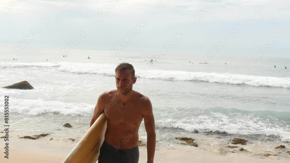 Man Coming in From Surfing Session on Tropical Sandy Beach in Sri Lanka Man Coming in From Surfing Session on Tropical Sandy Beach in Sri Lanka
